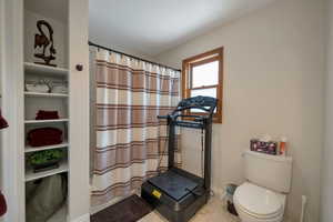 Bathroom with tile patterned floors and a shower with curtain