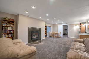 Carpeted living room featuring a tile fireplace and recessed lighting