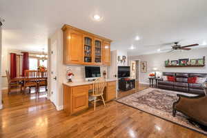 Living area with built in desk, light wood finished floors, ceiling fan, recessed lighting, and a chandelier