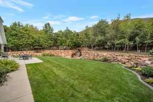View of grassy yard featuring a patio