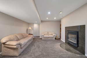 Living room with recessed lighting, a fireplace, and carpet floors