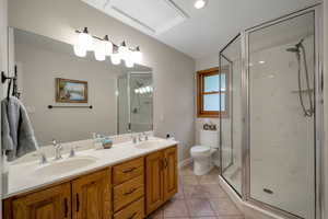 Bathroom featuring light tile patterned flooring, a marble finish shower, and double vanity