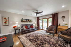Living room featuring light wood-style floors, ceiling fan, and recessed lighting