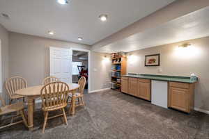 Dining area with dark carpet and baseboards