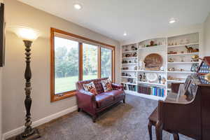 Living area featuring carpet floors, recessed lighting, and built in shelves