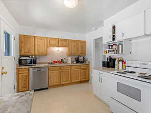 Kitchen featuring appliances with stainless steel finishes, light flooring, open shelves, and light stone counters