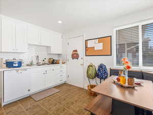 Kitchen with white cabinetry, dishwasher, decorative backsplash, light countertops, and recessed lighting