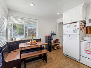 Kitchen with white appliances, recessed lighting, and white cabinetry