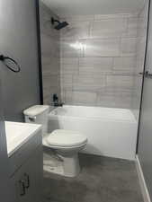 Full bath featuring washtub / shower combination, vanity, and concrete flooring