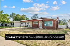 View of front facade featuring a chimney, brick siding, driveway, a gate, and covered porch