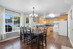 Dining area featuring a chandelier and dark wood-type flooring