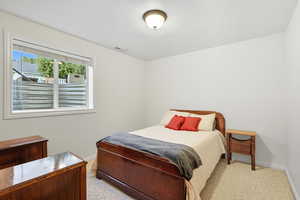 Bedroom 5 featuring light colored carpet and a textured ceiling