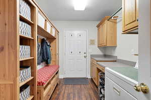 Mudroom featuring washer / dryer, dark wood-style flooring, a textured ceiling, and a sauna