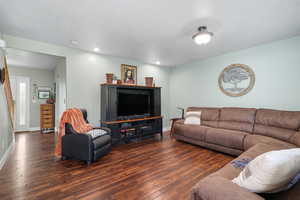 Living area with hardwood / wood-style flooring, a textured ceiling, and recessed lighting