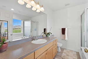 Primary Bathroom with a stall shower, a garden tub, vanity, and light tile patterned flooring
