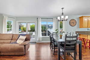 Dining space with dark wood-style flooring and a chandelier