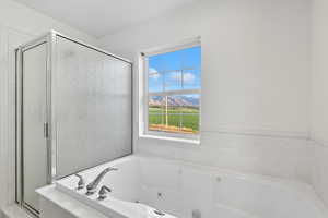 Primary Bathroom featuring a shower stall, a jetted tub, and a mountain view