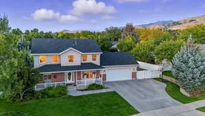 View of front of house featuring covered porch, roof with shingles, driveway, a gate, and brick siding