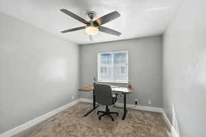 Office space with a textured ceiling and carpet floors