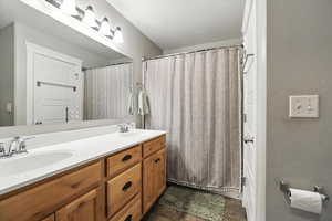 Full bathroom featuring double vanity and curtained shower