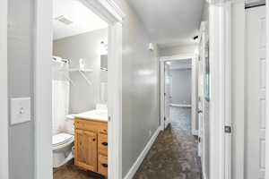 Full bathroom featuring vanity, curtained shower, and a textured ceiling