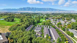 Aerial view of residential area with a golf club and a water and mountain view