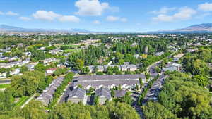 Aerial view of residential area featuring a mountainous background and a tree filled landscape