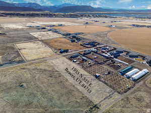 Aerial view of property and surrounding area featuring rural landscape and a mountain backdrop