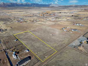 Aerial view of sparsely populated area with a mountainous background and property boundaries highlighted