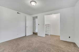 Unfurnished bedroom featuring light colored carpet