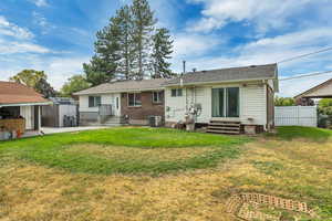 Rear view of house featuring entry steps and an outdoor structure