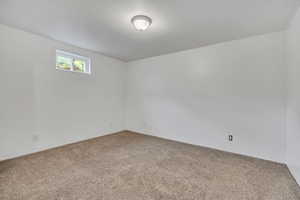 Empty room featuring light colored carpet and baseboards