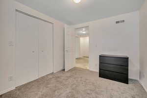 Unfurnished bedroom featuring carpet and a closet