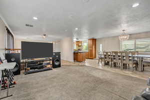 Living room with light carpet, crown molding, light tile patterned floors, recessed lighting, and a chandelier
