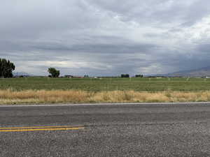 View of asphalt road with a view of rural / pastoral area