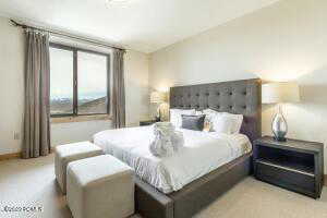 Bedroom with baseboards and light carpet