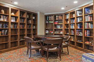 Office area featuring wall of books and recessed lighting