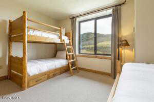 Bedroom featuring multiple windows and light colored carpet