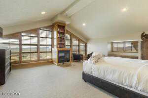 Bedroom featuring light colored carpet and a fireplace