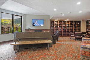Living area featuring wall of books and recessed lighting