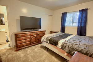 Bedroom featuring light carpet and a closet