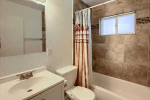 Full bath featuring shower / bathtub combination with curtain and vanity
