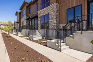 View of exterior entry featuring stone siding and a residential view