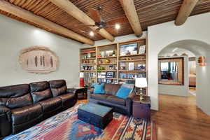 Second Living area featuring arched walkways, a wooden ceiling with exposed beams, wood finished floors, and a ceiling fan