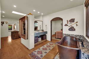 Hall with light wood-style flooring, recessed lighting, and a skylight