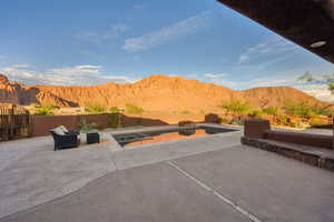 Fenced backyard featuring a mountain view and a patio area