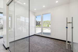 Spare room featuring dark carpet and recessed lighting