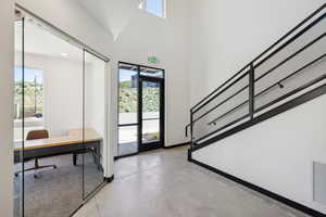 Foyer entrance with finished concrete floors and a towering ceiling