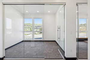 Doorway featuring healthy amount of natural light, carpet flooring, and recessed lighting