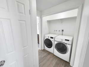 Washroom featuring dark wood-style floors and washing machine and clothes dryer